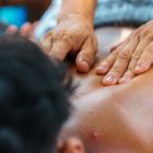 Close-up of hands performing a therapeutic back massage, promoting relaxation and wellness.