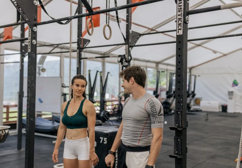Man and woman exercising at an indoor gym, focused on fitness goals.